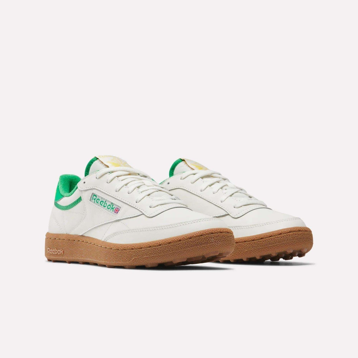 Men's Club C Golf Shoes by Reebok in white with green accents, a gum rubber spikeless outsole, and the Reebok logo on the side, shown against a plain white background.
