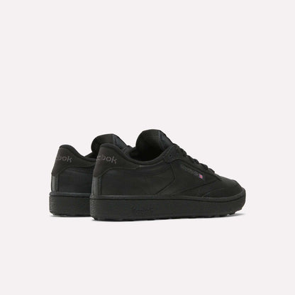The Reebok Men's Club C Golf Shoes in black feature a low-top, spikeless design. Displayed from the back and side on a white background, the Reebok logo appears on both the heel and side.