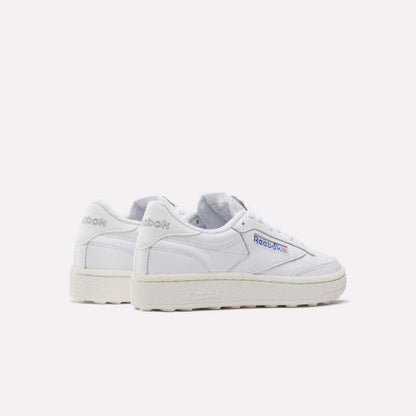 The Women's Club C Golf Shoes by Reebok are classic white sneakers with off-white soles and a spikeless outsole, featuring the Reebok logo on the side and heel. They are photographed against a plain white background.