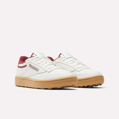 A pair of Women's Club C Golf Shoes by Reebok, featuring white water-resistant leather, maroon accents, and a spikeless outsole, shown on a plain white background.
