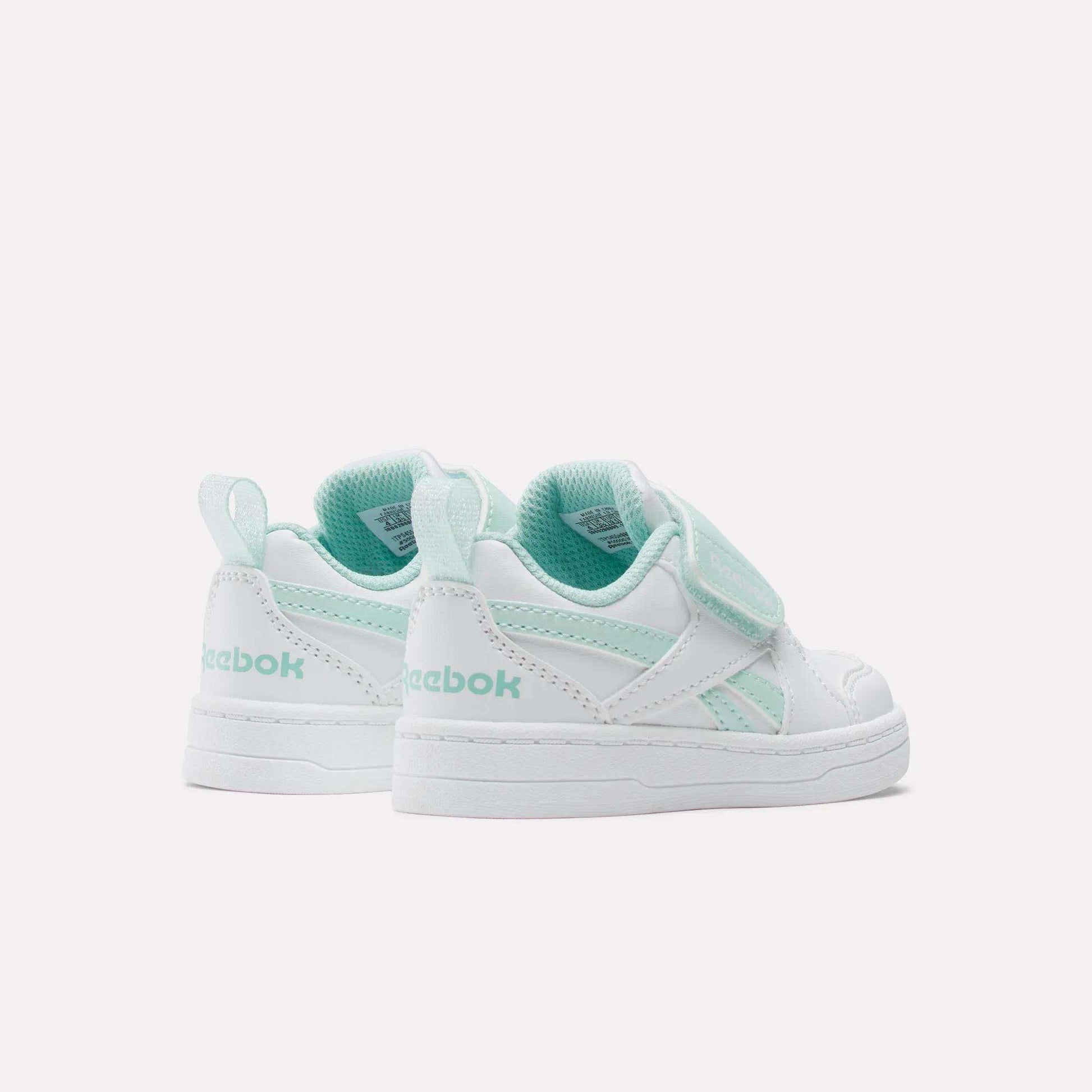 The Reebok Kids' Royal Prime Snug Shoes - Baby & Toddler in white and mint green feature Velcro straps for easy wear. Shown from the back and side on a plain white background, they combine style and convenience for little ones.