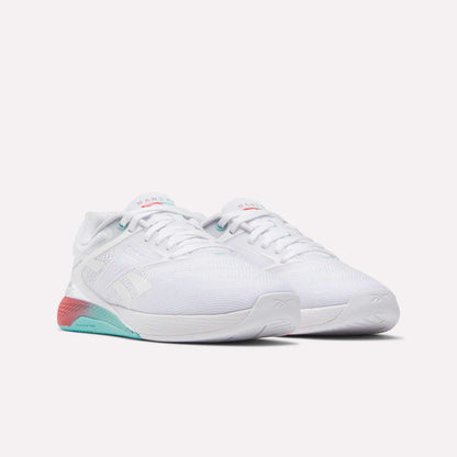The Reebok Women's Nano X5 Training Shoes are comfortable white athletic sneakers with teal and pink accents on the sole and heel, shown side by side on a plain white background—ideal for any workout.