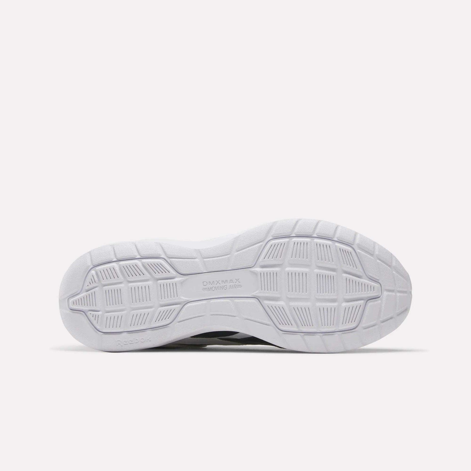 The image shows the white outsole of the Reebok Men's Walk Ultra 7 DMX Max Wide 4E Shoes, featuring a textured geometric tread with grooves, squares, and rectangles for grip. The DMX MAX branding appears near the center.