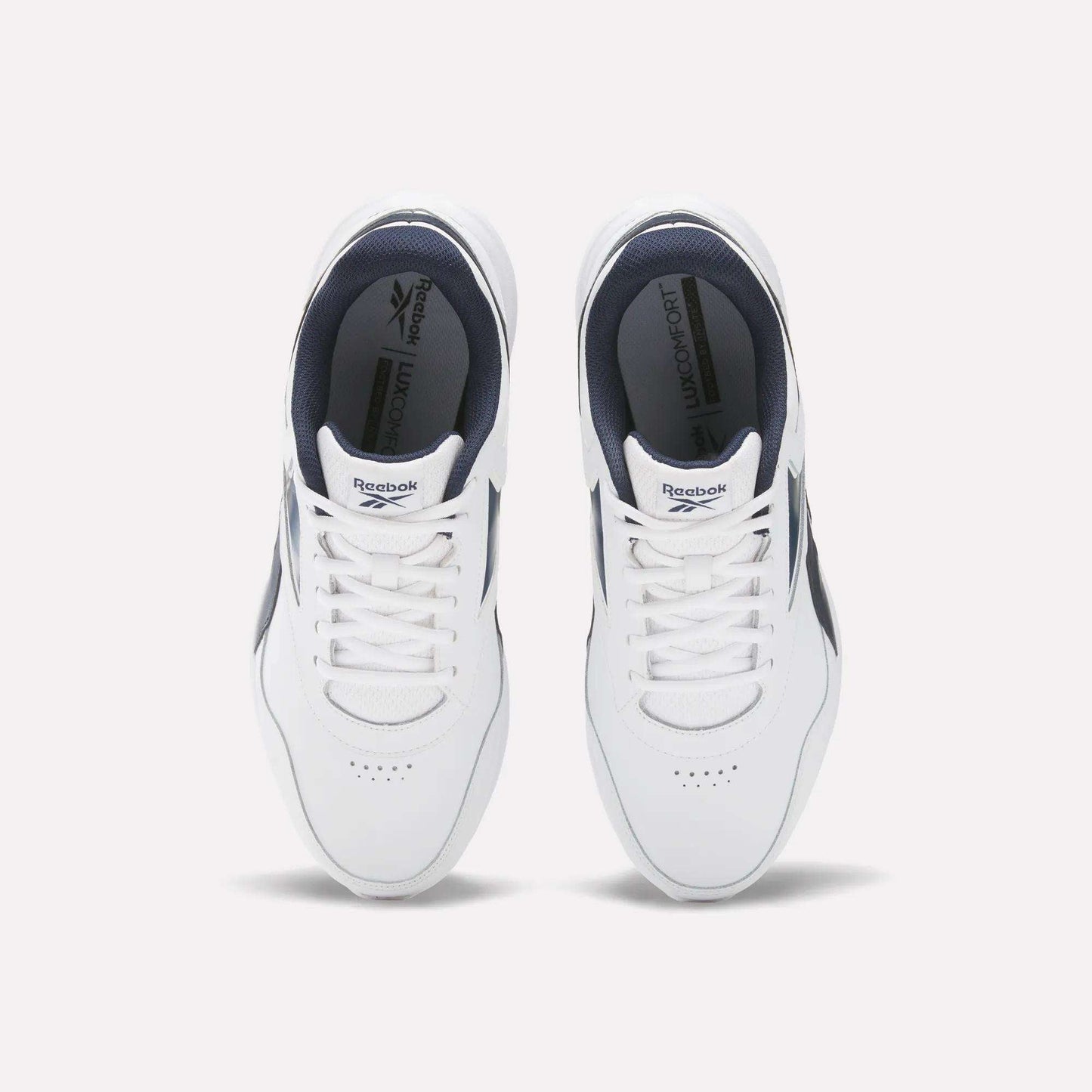 Top view of Reebok Men's Walk Ultra 7 DMX Max Wide 4E Shoes in white with navy accents and white laces, side by side on a light background. These wide-fit walking shoes offer comfort and style, featuring insoles with the Reebok logo.