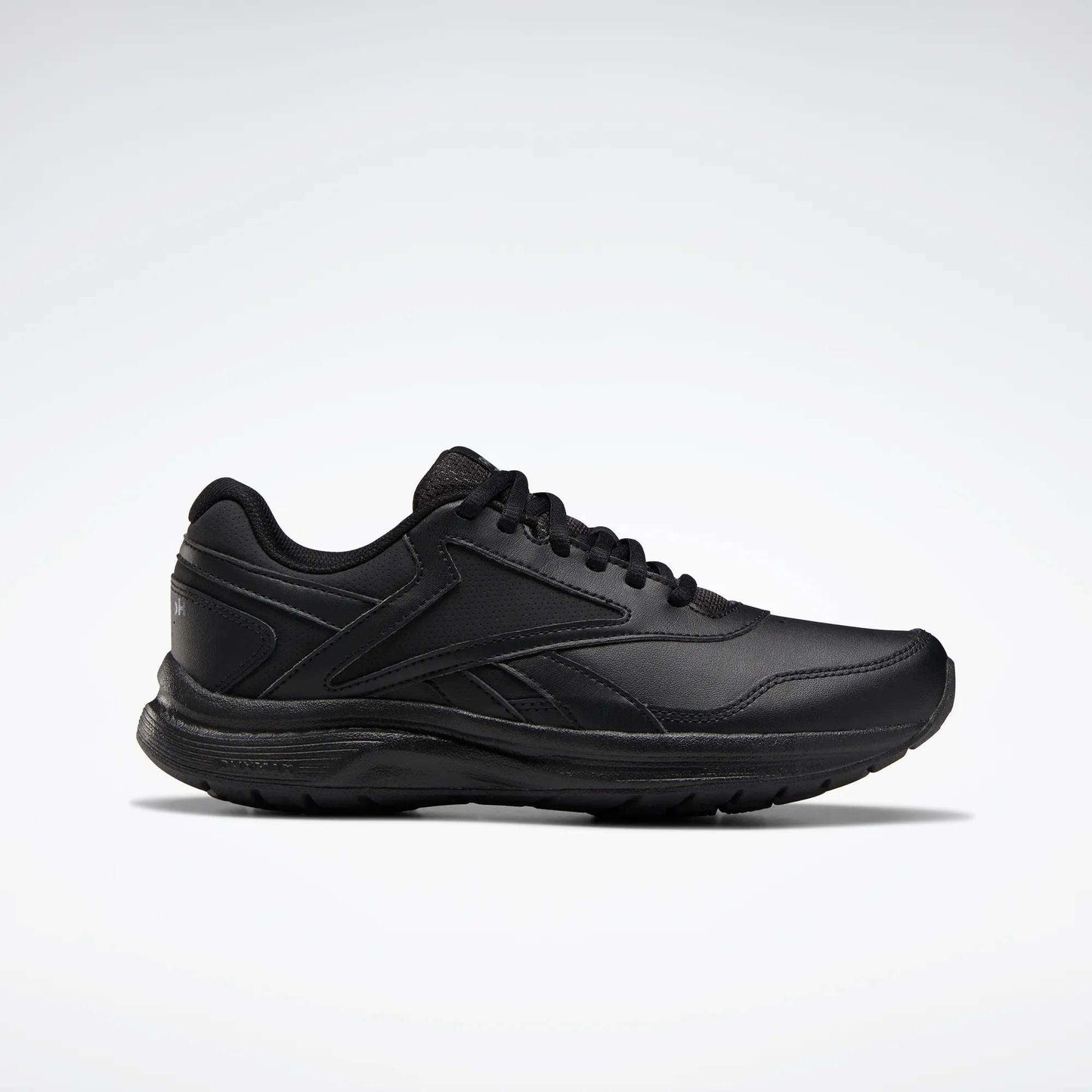 The Reebok Women's Walk Ultra 7 DMX Max Walking Shoes are black, low-profile sneakers with lace-up closure and minimalist design. Side view against a light gray background. Ideal for fans of Reebok walking shoes seeking comfort and style.