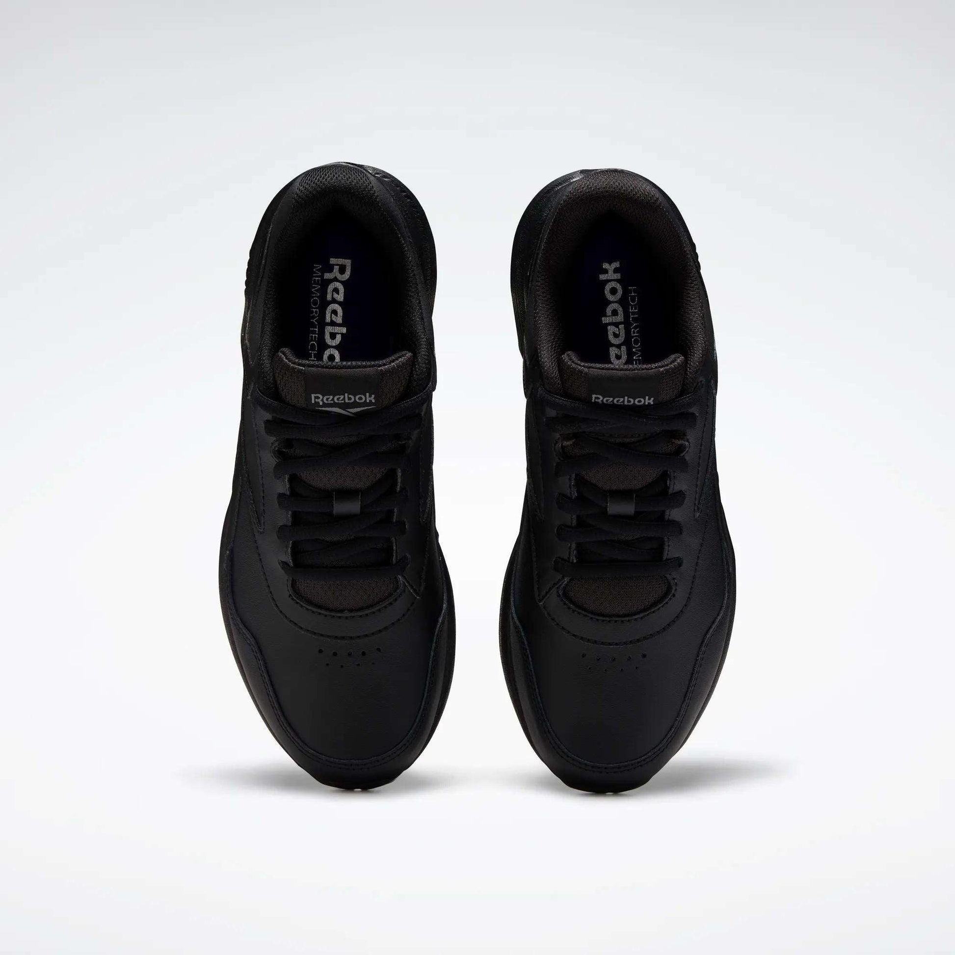 A pair of Women's Walk Ultra 7 DMX Max Walking Shoes by Reebok, shown from above with black laces and a minimalist design featuring DMX cushioning for comfort, set against a plain white background.