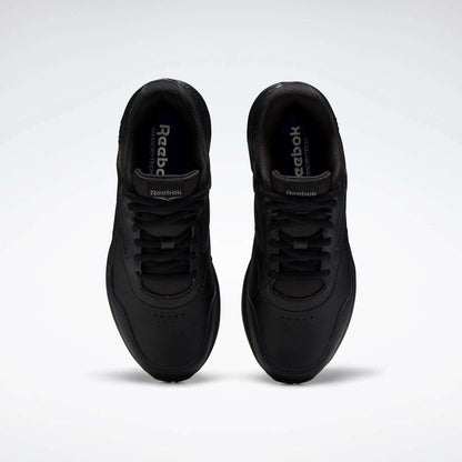A pair of Women's Walk Ultra 7 DMX Max Walking Shoes by Reebok, shown from above with black laces and a minimalist design featuring DMX cushioning for comfort, set against a plain white background.