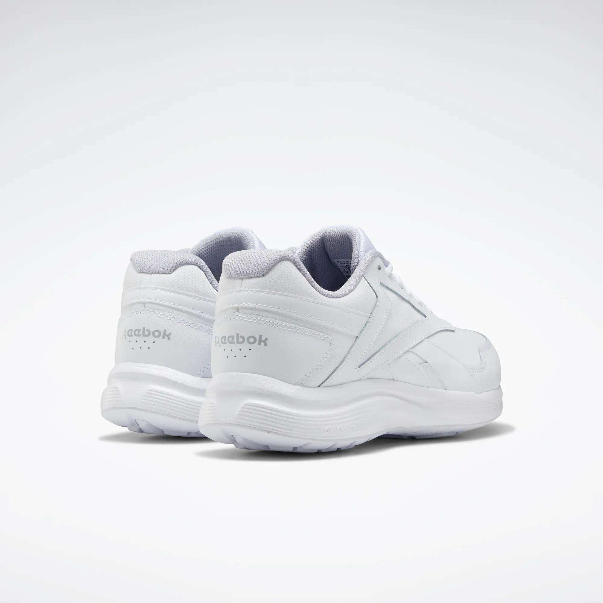 The Reebok Women's Walk Ultra 7 DMX Max Walking Shoes are displayed all in white on a light background, with one shoe slightly ahead to show both the side and back views. These walking shoes offer DMX cushioning for all-day comfort.