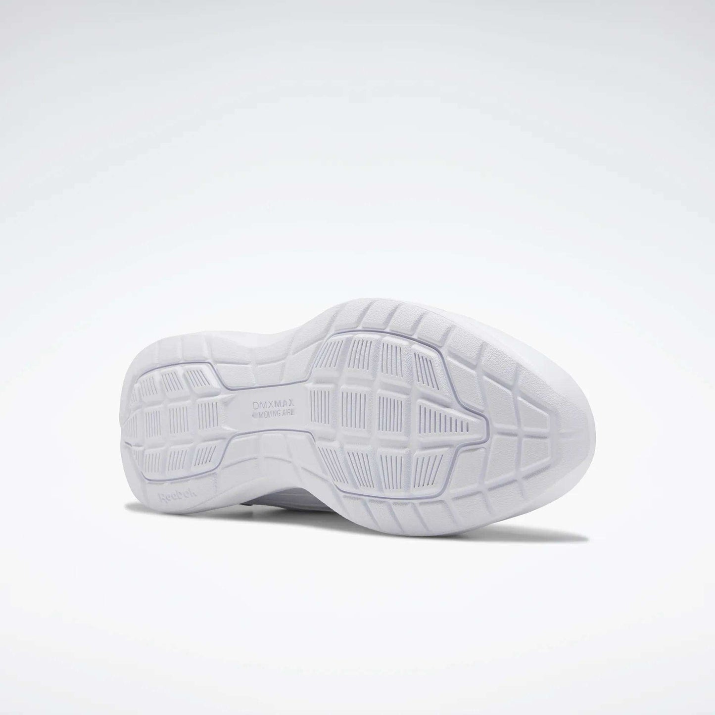 The image shows the sole of a Reebok Women's Walk Ultra 7 DMX Max Walking Shoe. Its white, textured grip and DMX cushioning enhance comfort. The shoe is positioned on its side against a plain, light background.