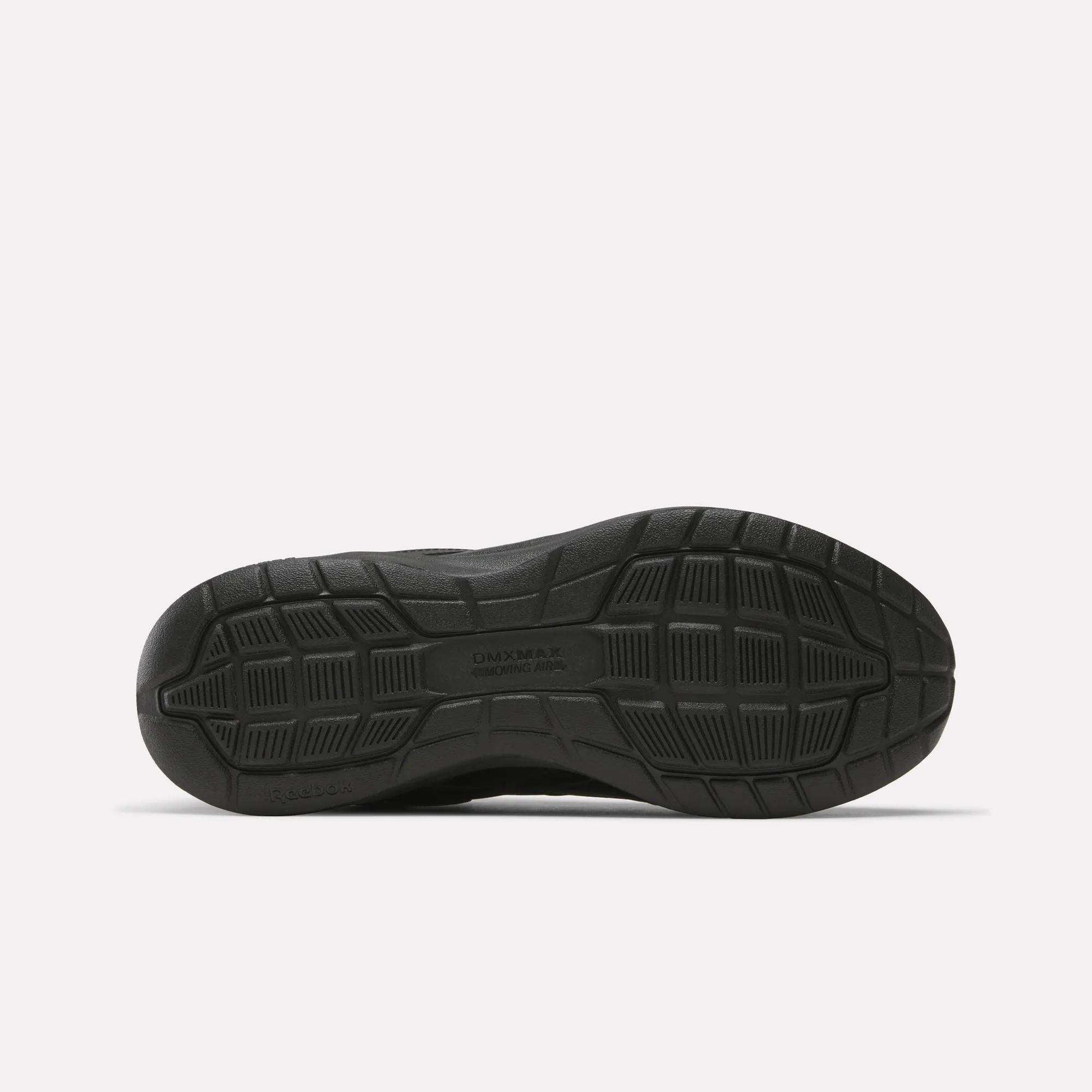 Black sole with geometric tread patterns and grooves, shown from below against a white background. Designed for grip and durability, this sole is typical of cushioned Reebok Walk Ultra 7 DMX Max Walking Shoes.