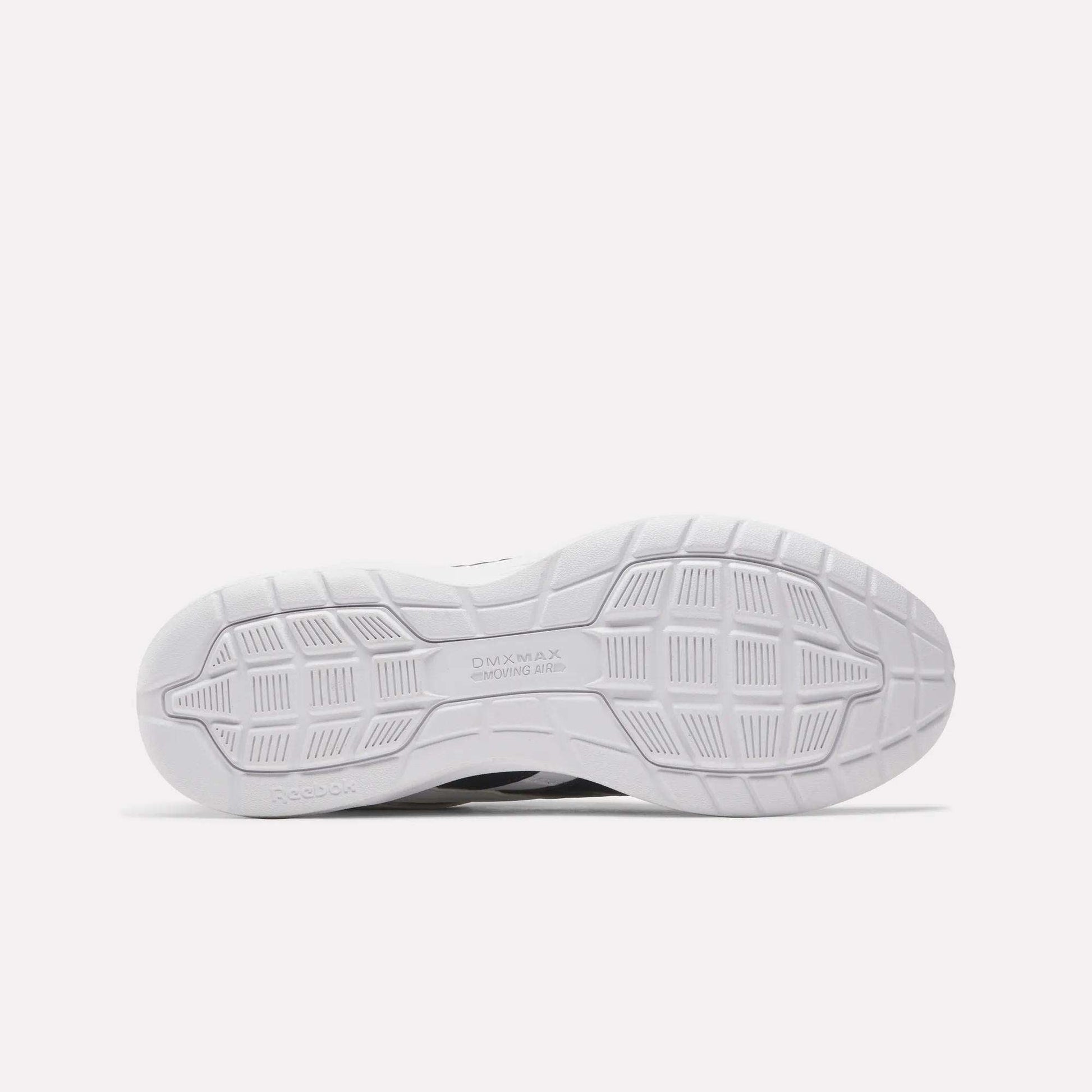The image displays the white rubber outsole of Reebok Walk Ultra 7 DMX Max Walking Shoes, featuring a patterned tread with grooves and geometric shapes for traction. "DMX MAX" and "Reebok" are embossed, emphasizing their cushioned comfort.