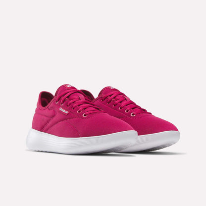 A pair of Women's Active Lite Shoes by Reebok in bright pink with white soles, featuring laces and a simple, modern design, shown at an angle on a plain light background.