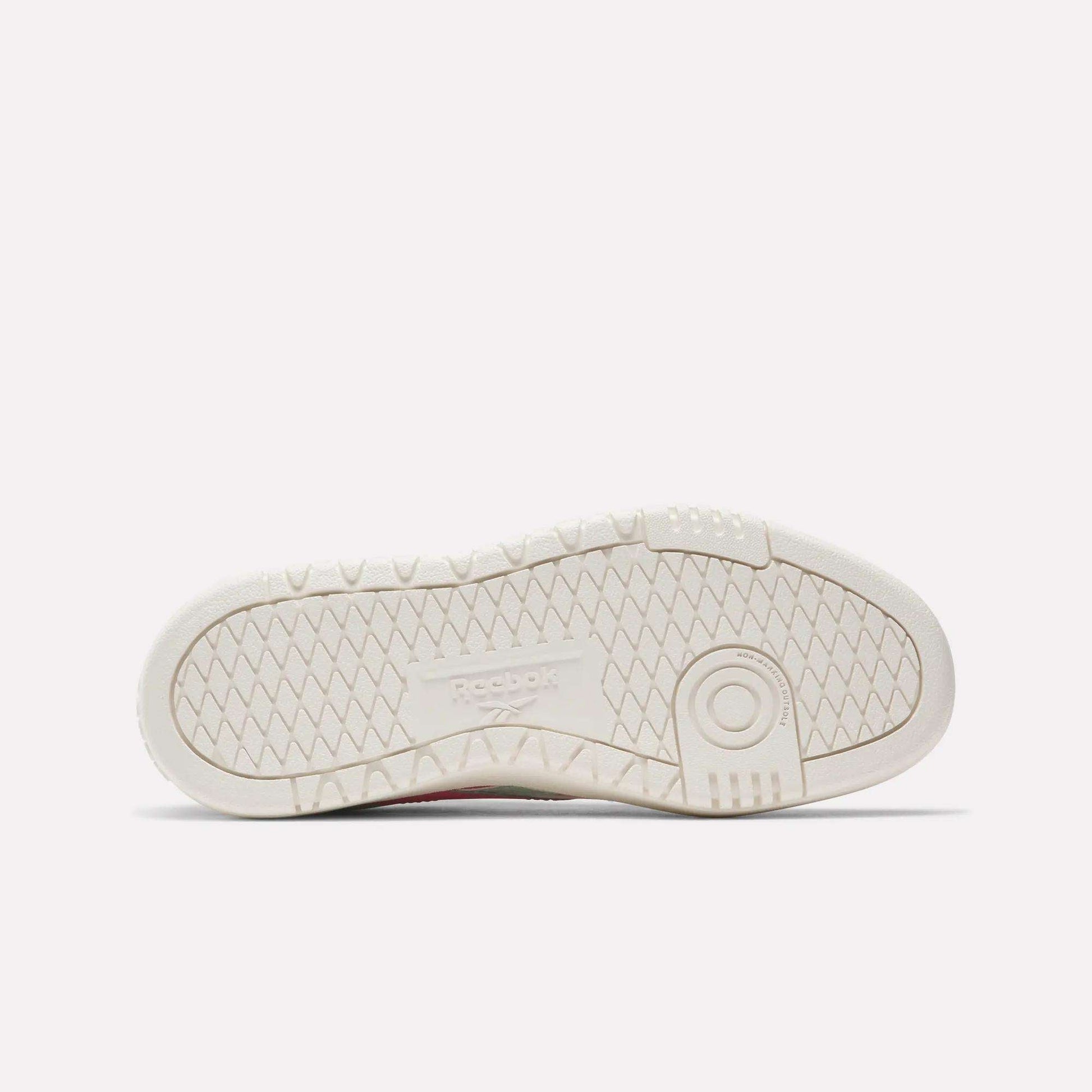 The image shows the sole of a white Reebok Campio XT Double Shoe for big kids, featuring a textured zigzag tread pattern and an embossed Reebok logo—ideal for fans of classic retro sneakers.