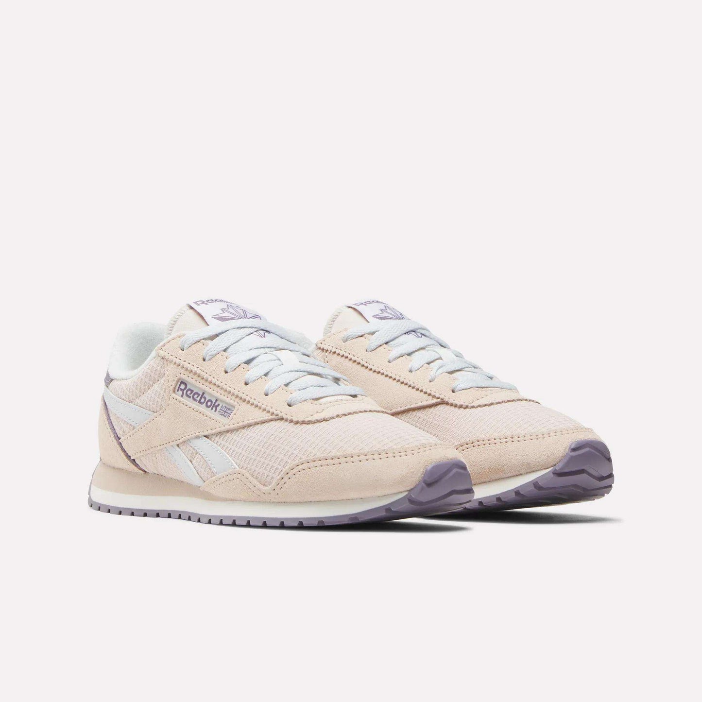 The Women's Classic AZ Shoes by Reebok are beige with white accents, a light purple outsole, and classic branding on the side and tongue, shown against a white background.