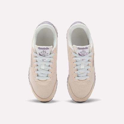 The Women's Classic AZ Shoes by Reebok are beige with white laces and light purple branding, shown from above on a white background—ideal for fans of 70s-style sneakers.