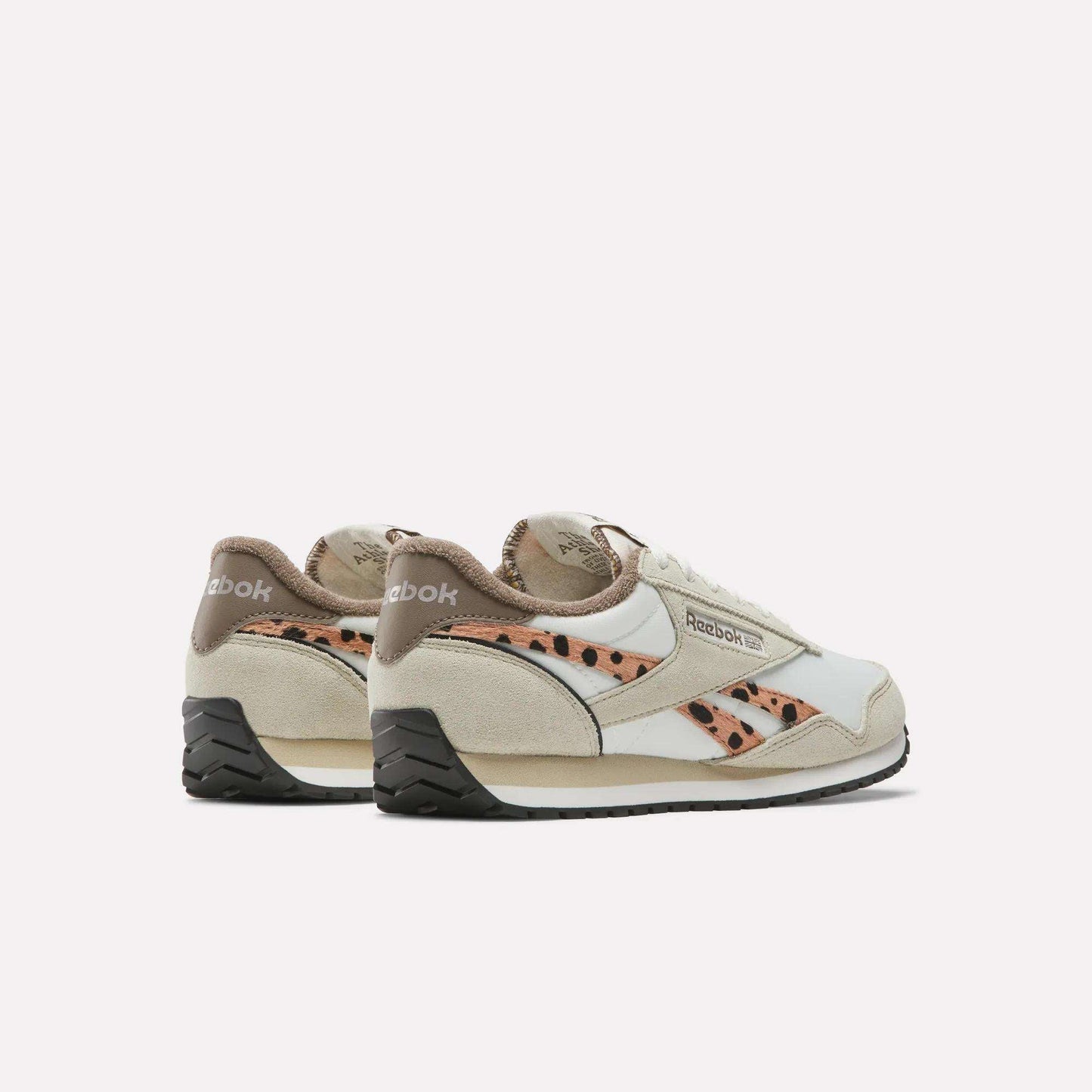 The Reebok Women's Classic AZ Shoes feature beige suede, white leather accents, a cheetah print design on the side, black soles, and Reebok branding on the heel and side.