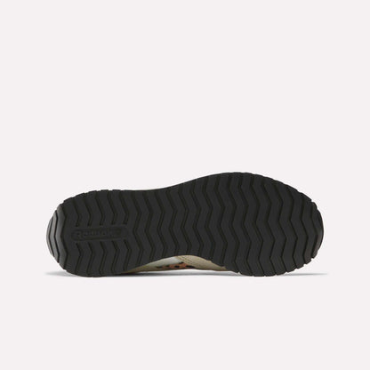 The image displays the black, textured rubber outsole of Reebok Women's Classic AZ Shoes from the bottom on a plain white background, showing a zigzag tread pattern with the Reebok logo on the left side.