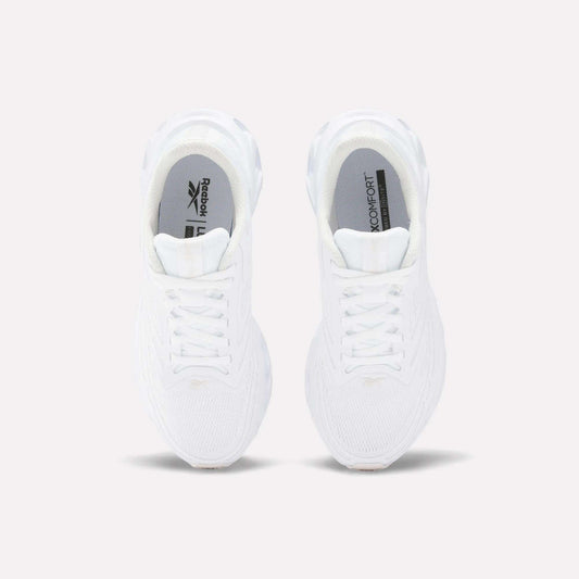 Top view of Reebok Women's Fuel Flex Run Shoes in white with white laces, gray insoles featuring the Reebok logo and "MEMORY TECH" text, and a plush Fuel Flex midsole, set on a plain light background.