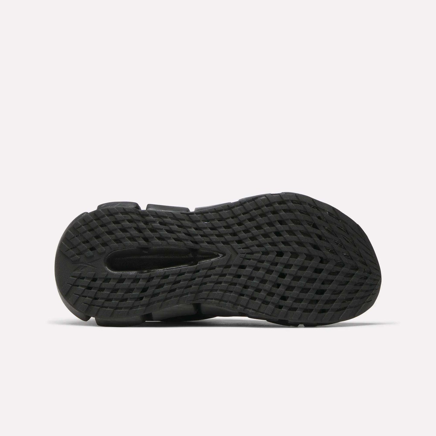 The image shows the bottom view of the Reebok Women's FloatZig 2 Running Shoes' black sole, featuring a textured, grid-like pattern and traction grooves with energy-returning Superfloat+ cushioning, set against a plain white background.
