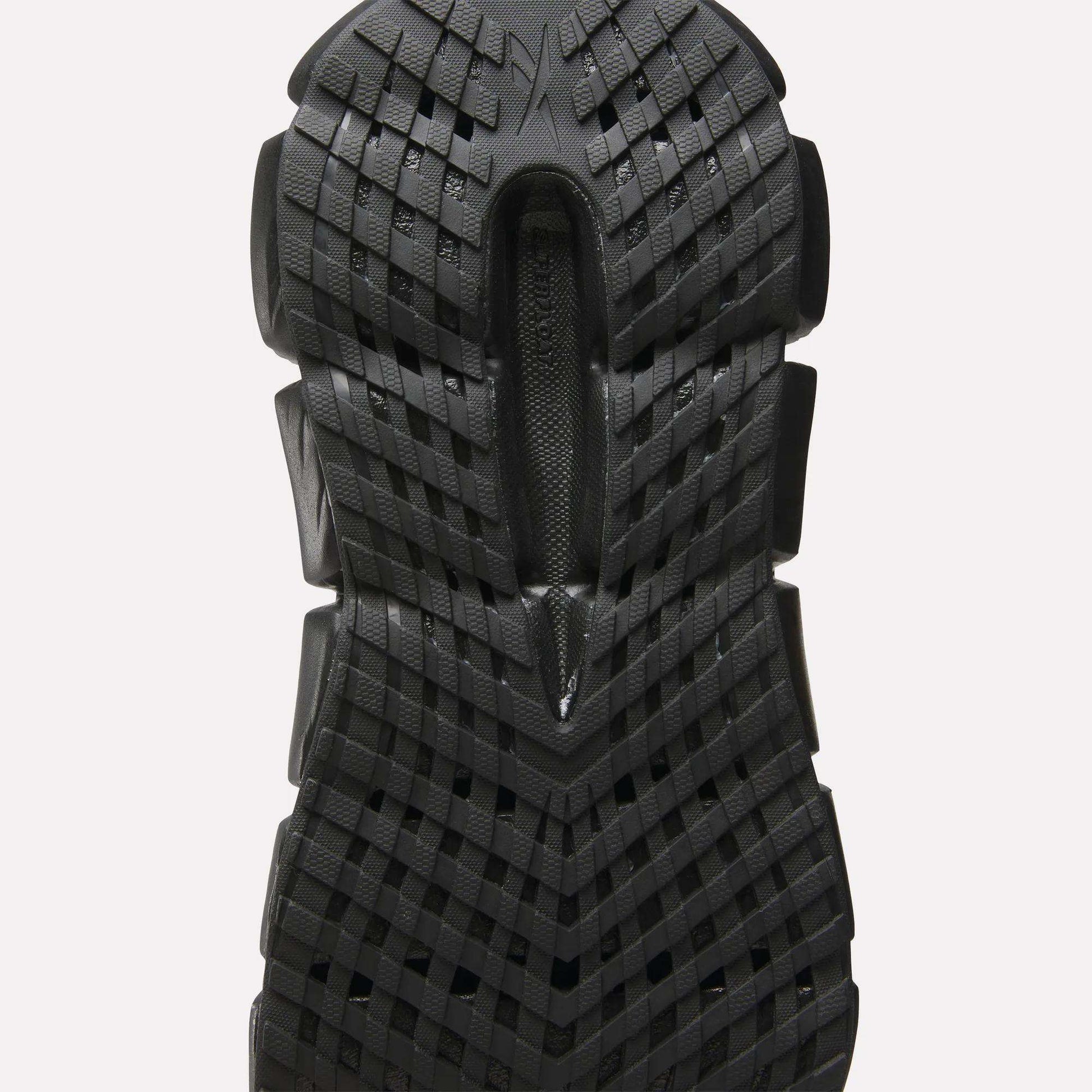Close-up of a black sole on Reebok Women's FloatZig 2 Running Shoes, showcasing a textured grid pattern with raised sections for traction and energy-returning Superfloat+ cushioning inspired by high-performance running footwear.