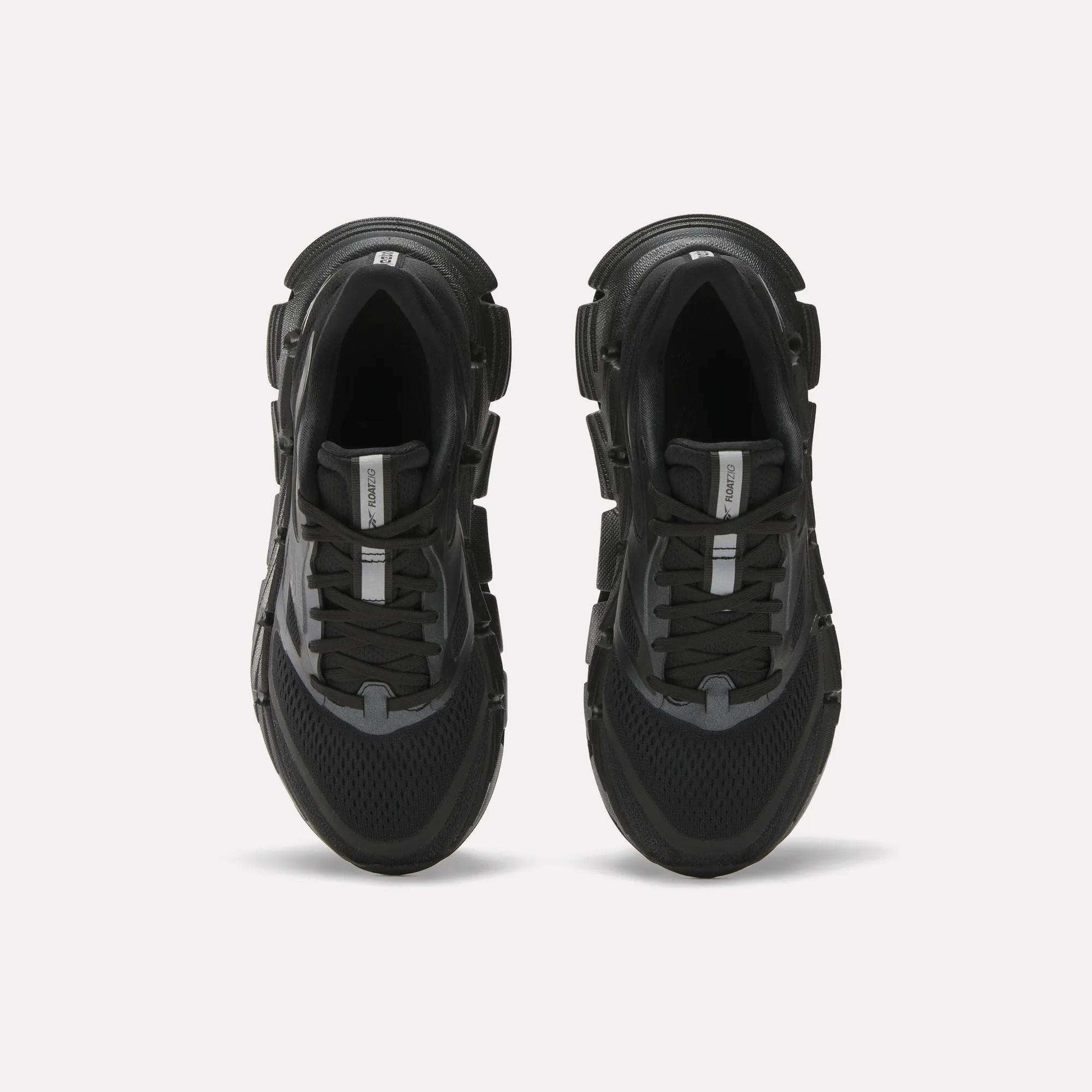 A pair of Reebok Women's FloatZig 2 black running shoes with thick soles, black laces, mesh detailing, and Superfloat+ cushioning, viewed from above on a plain white background.