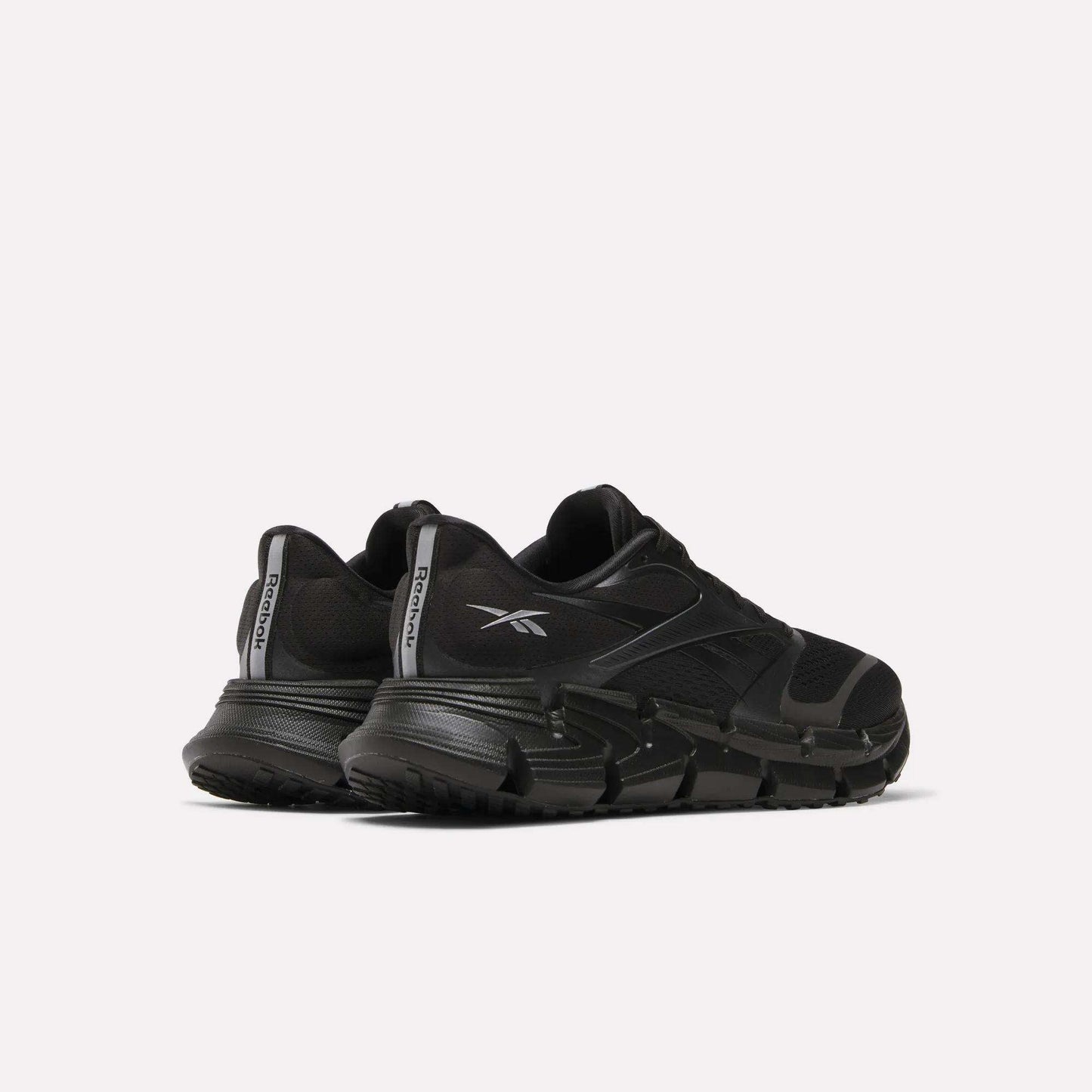 A pair of Reebok Men's FloatZig 2 Running Shoes in black with thick, energy-returning cushioning soles and bold logos, positioned side by side at an angle on a plain white background.
