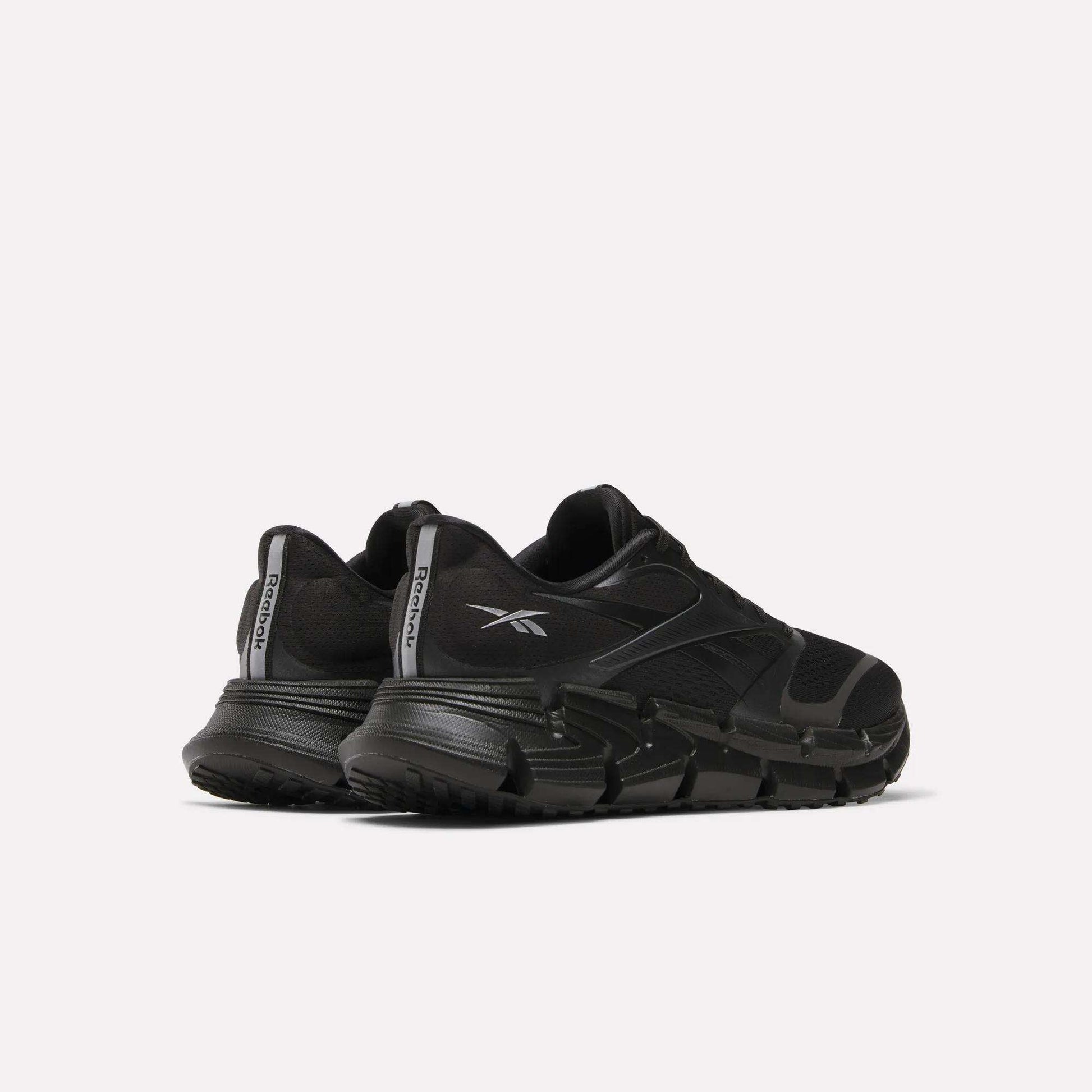 A pair of Reebok Men's FloatZig 2 Running Shoes in black with thick, energy-returning cushioning soles and bold logos, positioned side by side at an angle on a plain white background.