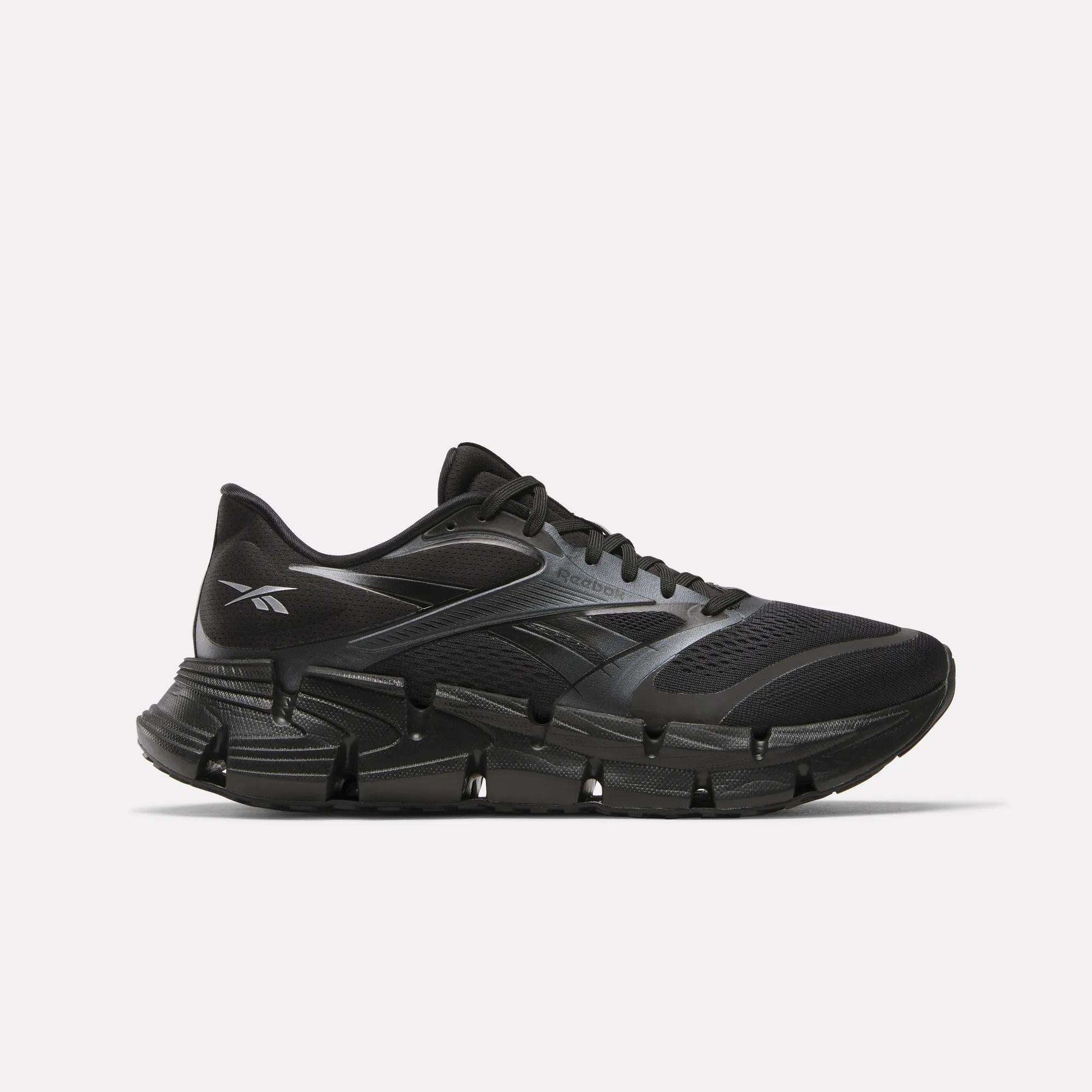 The Reebok Men's FloatZig 2 Running Shoes feature a black mesh upper, segmented sole, and energy-returning cushioning, shown in a sleek side view on a plain white background.