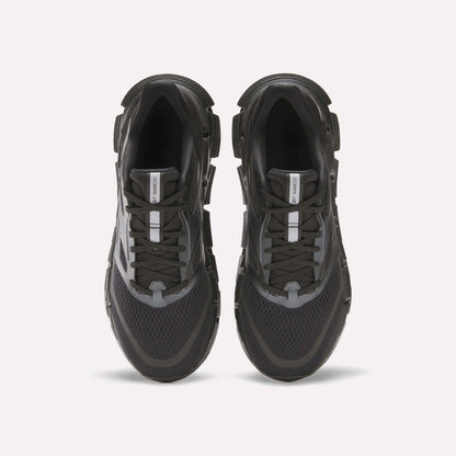 The Reebok Men's FloatZig 2 Running Shoes in black and gray are shown from above on a white background, featuring mesh panels, energy-returning cushioned soles, lace-up design, and a central logo tag on the tongue.