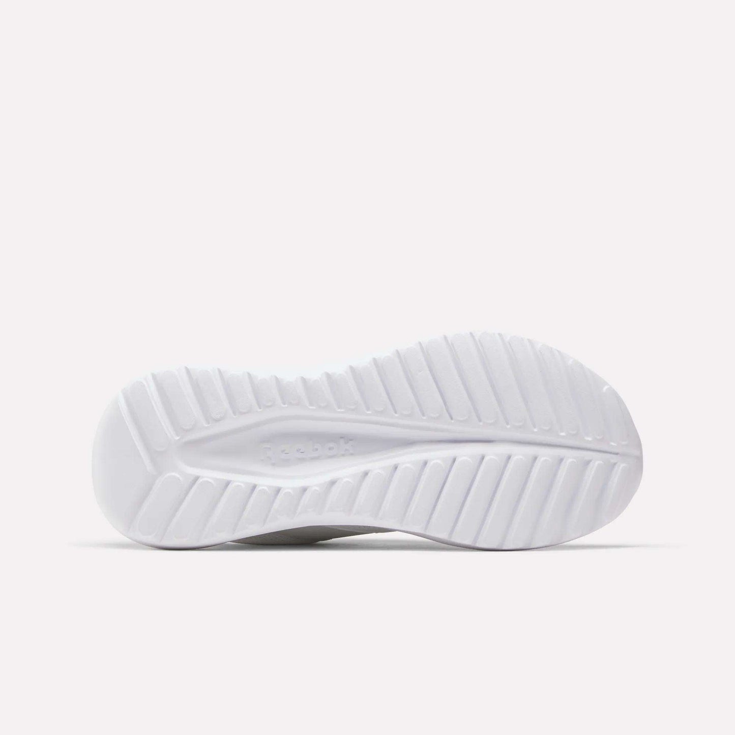 The white sole of the Reebok Women's Energen Lux Running Shoes, designed with a ridged, textured tread for grip and flexibility, is photographed against a plain light background.