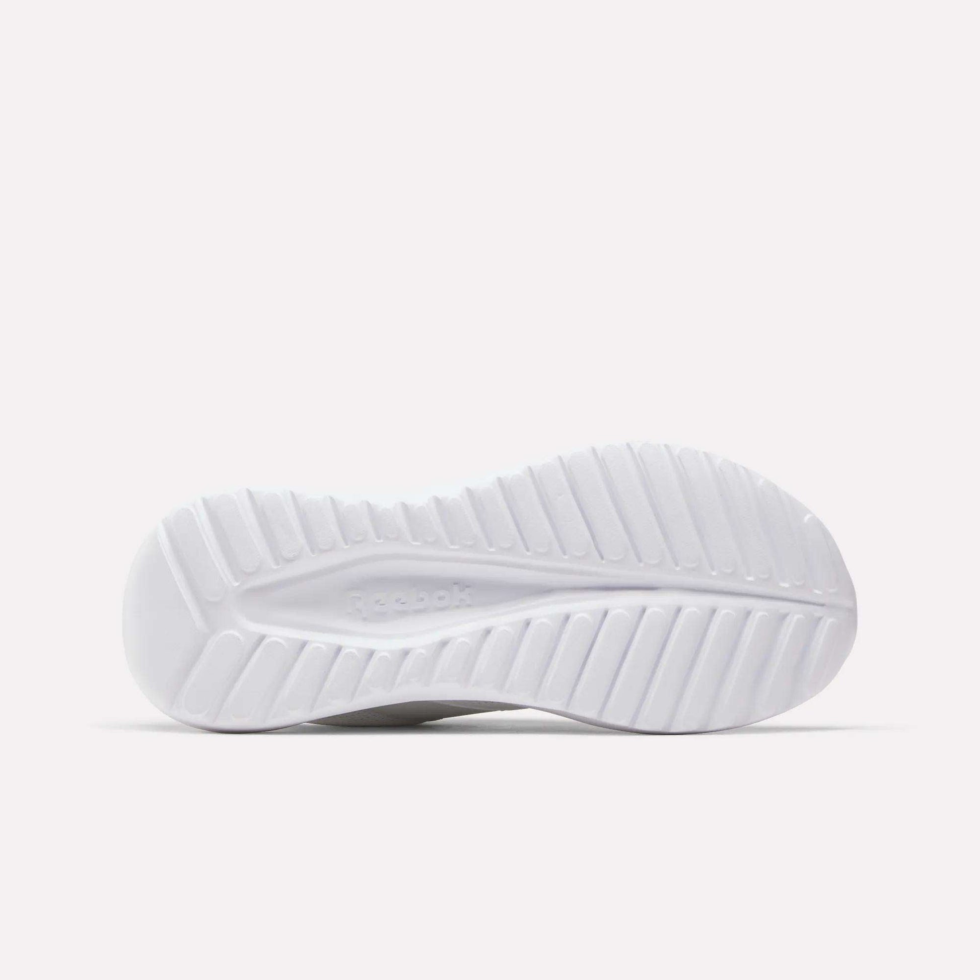 The white sole of the Reebok Women's Energen Lux Running Shoes, designed with a ridged, textured tread for grip and flexibility, is photographed against a plain light background.