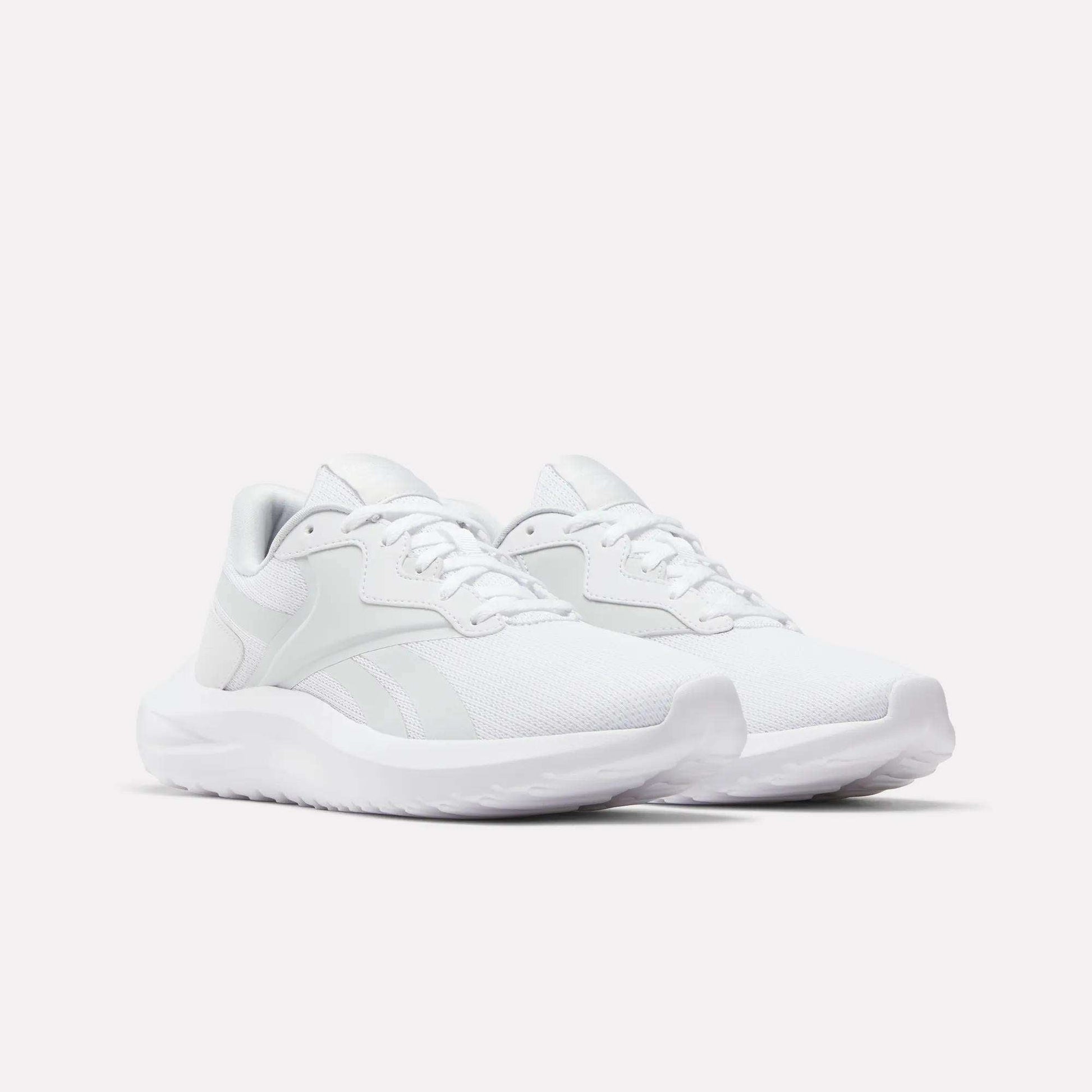 A pair of Reebok Women's Energen Lux Running Shoes with mesh uppers, white laces, and thick white soles is displayed on a plain light background.