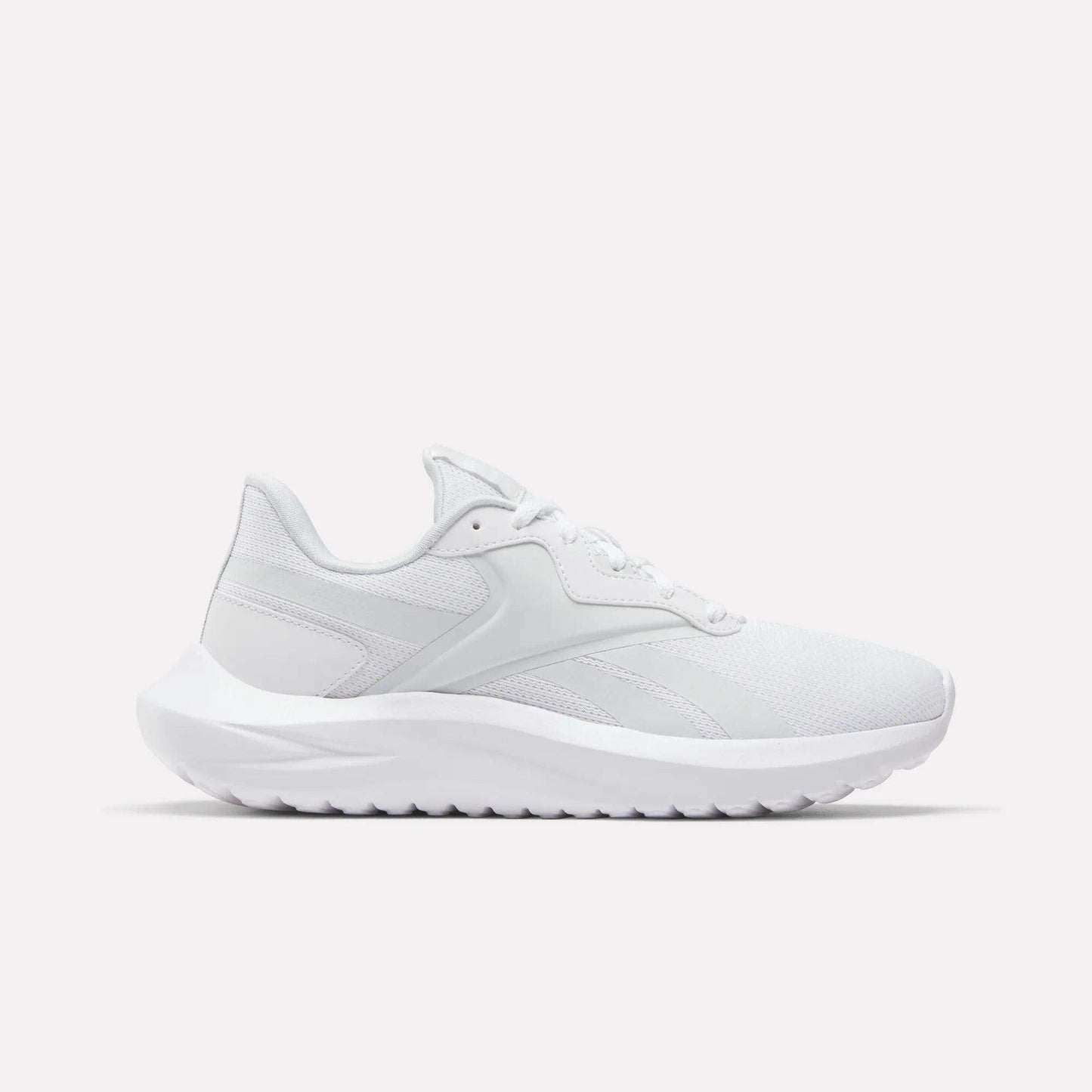 The Reebok Women's Energen Lux Running Shoes feature a white mesh upper, lace-up closure, and a thick textured sole—versatile athletic sneakers showcased on a plain white background.