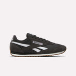 The Reebok Classic AZ Shoes in black feature white and gray accents, white side stripes, and a brown rubber sole that channels true '70s style, shown against a plain light background.