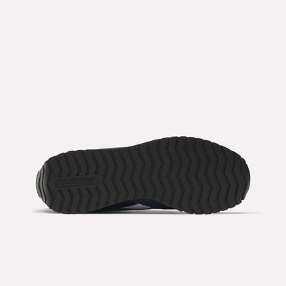 The image displays the bottom view of a black Reebok Classic AZ Shoes sole, featuring a zigzag tread pattern inspired by retro running shoes, all set against a plain white background.