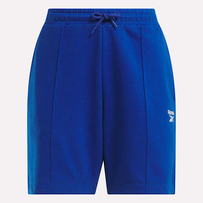 Reebok Women's Pintuck Long Shorts in bright blue feature soft cotton-blend fleece, an elastic waistband with drawstring, side pockets, and a white logo on the left thigh.