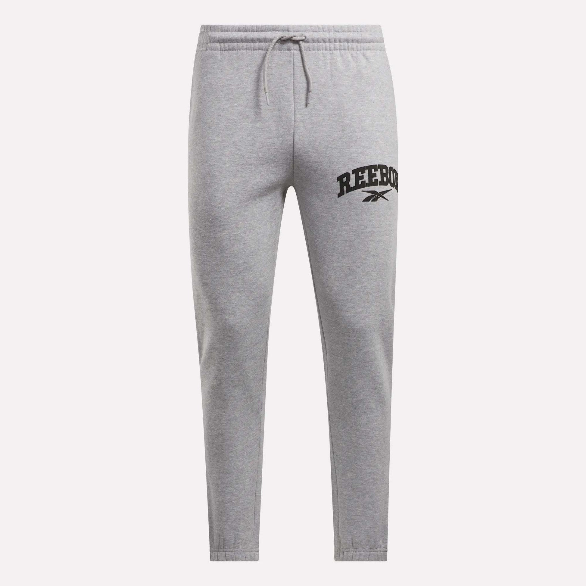 Reebok Men's Joggers in light gray, crafted from soft fleece with an elastic waistband, drawstring, and tapered legs. The left thigh features a black Reebok logo and vector symbol. Shown on a plain white background.