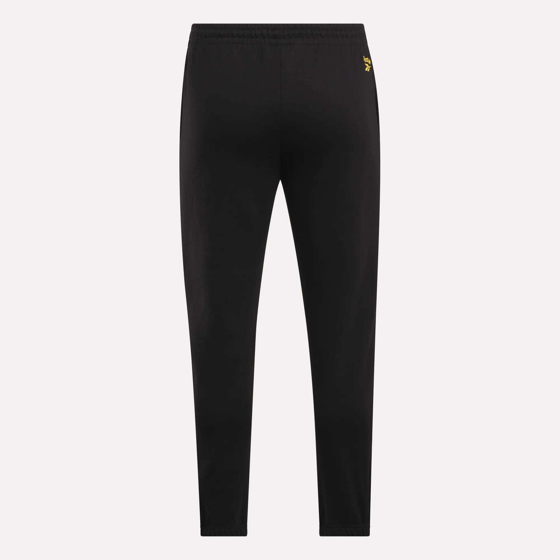 Reebok Men's Joggers shown from the back on a light background, featuring a slim fit, elastic waistband, and a small yellow logo near the waist for a stylish touch.