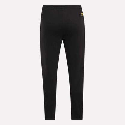 Reebok Men's Joggers shown from the back on a light background, featuring a slim fit, elastic waistband, and a small yellow logo near the waist for a stylish touch.