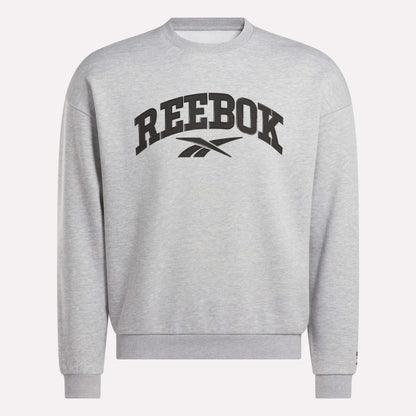 The Reebok Men's Cottle Sweatshirt is light grey with a black Reebok logo and brand name on the chest. This crewneck features long sleeves, ribbed cuffs and hem, and provides a relaxed, casual fit.