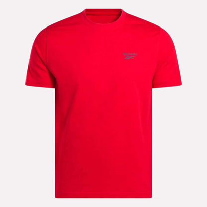 The Reebok Men's Small Logo Crewneck Short Sleeve T-Shirt is a bright red cotton jersey tee with a crew neckline and a small gray logo on the left chest, shown on a plain white background.