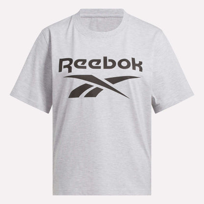 The Reebok Women's Big Logo Oversized Crew Short Sleeve Tee is a light gray shirt with a bold black Reebok logo across the chest, designed in an oversized fit for casual comfort.