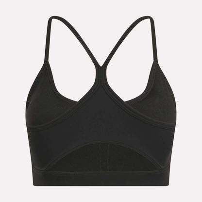 The Reebok Women's Core Strappy Bra offers medium support with thin, crisscrossed racerback straps and a seamless black design—ideal for workouts. Displayed on a plain white background.