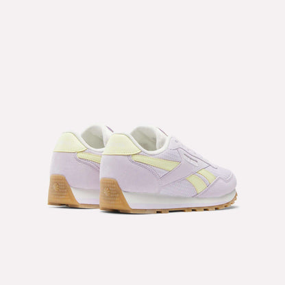 The Reebok Classic AZ Shoes - Big Kids, in pastel purple and yellow with gum soles and foam cushioning, are shown from a rear side angle against a plain white background.