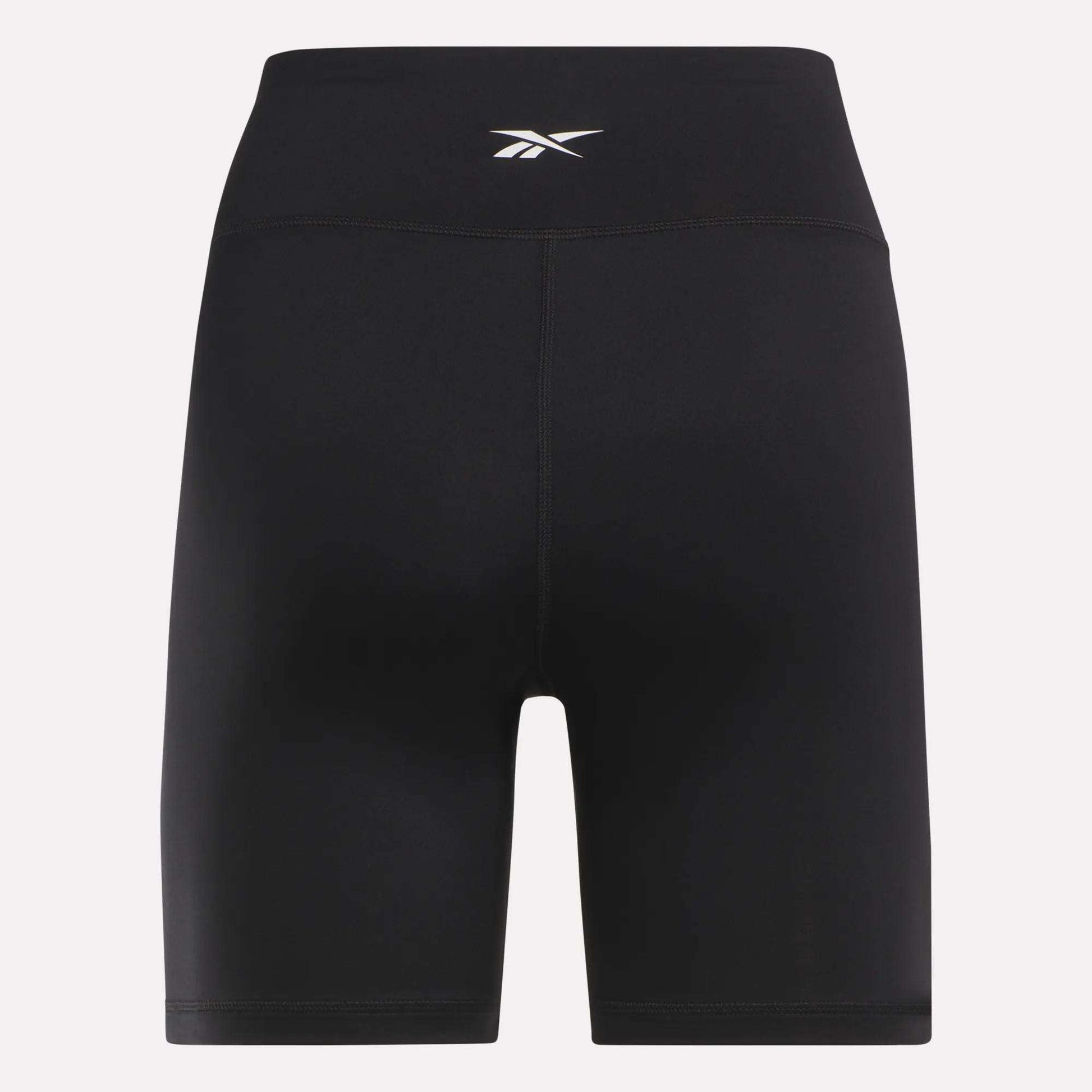 Reebok Women's Core High-Rise Cycle Shorts feature a small white logo on the waistband. Made from smooth, stretchy, sweat-wicking fabric, they're perfect for cycling or workouts. Shown against a plain light background.