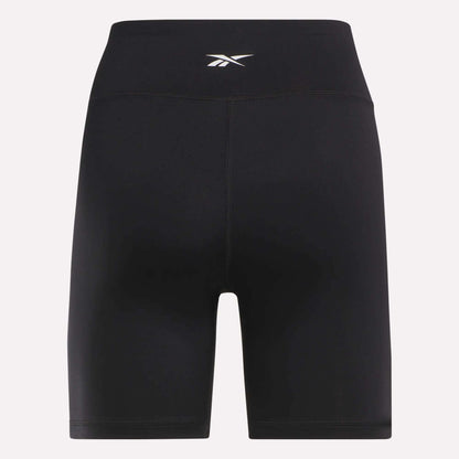 Reebok Women's Core High-Rise Cycle Shorts feature a small white logo on the waistband. Made from smooth, stretchy, sweat-wicking fabric, they're perfect for cycling or workouts. Shown against a plain light background.