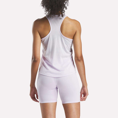 A person with curly hair is shown from the back, wearing the Reebok Women's Core Tank Top in light purple with matching fitted shorts, set against a plain white background.