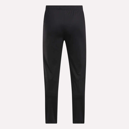 Men's Train Knit Pants by Reebok shown from the back, featuring a slim fit and elastic waistband, set against a plain light background.