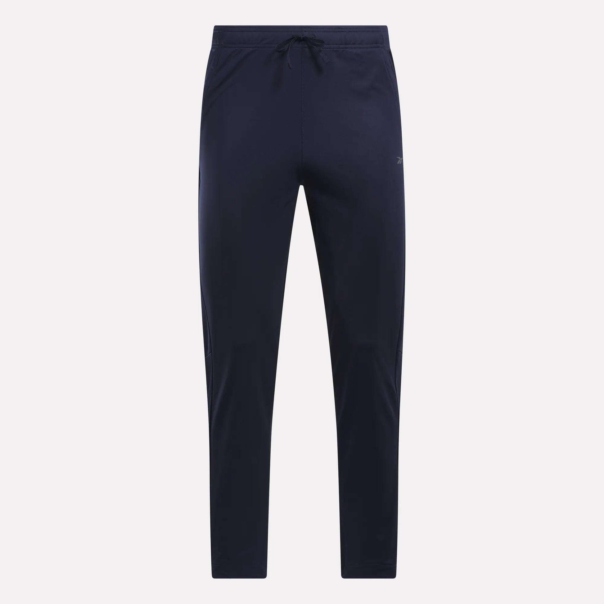 Reebok Men's Train Knit Pants in navy blue, featuring a slim fit jogger style with an elastic waistband and drawstring. Displayed against a plain light background, these gym pants have no visible logos or patterns.