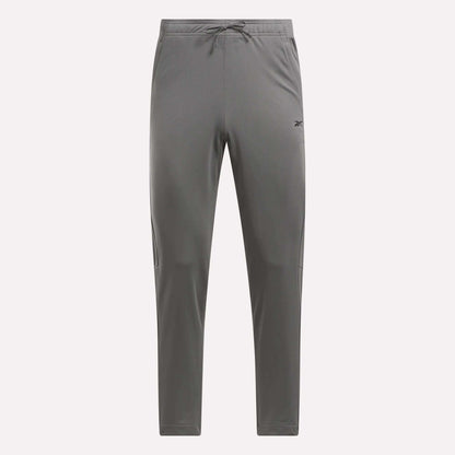 Men's Train Knit Pants by Reebok, gray with a drawstring waistband, tapered legs, and a small logo on the left thigh, shown against a plain white background.